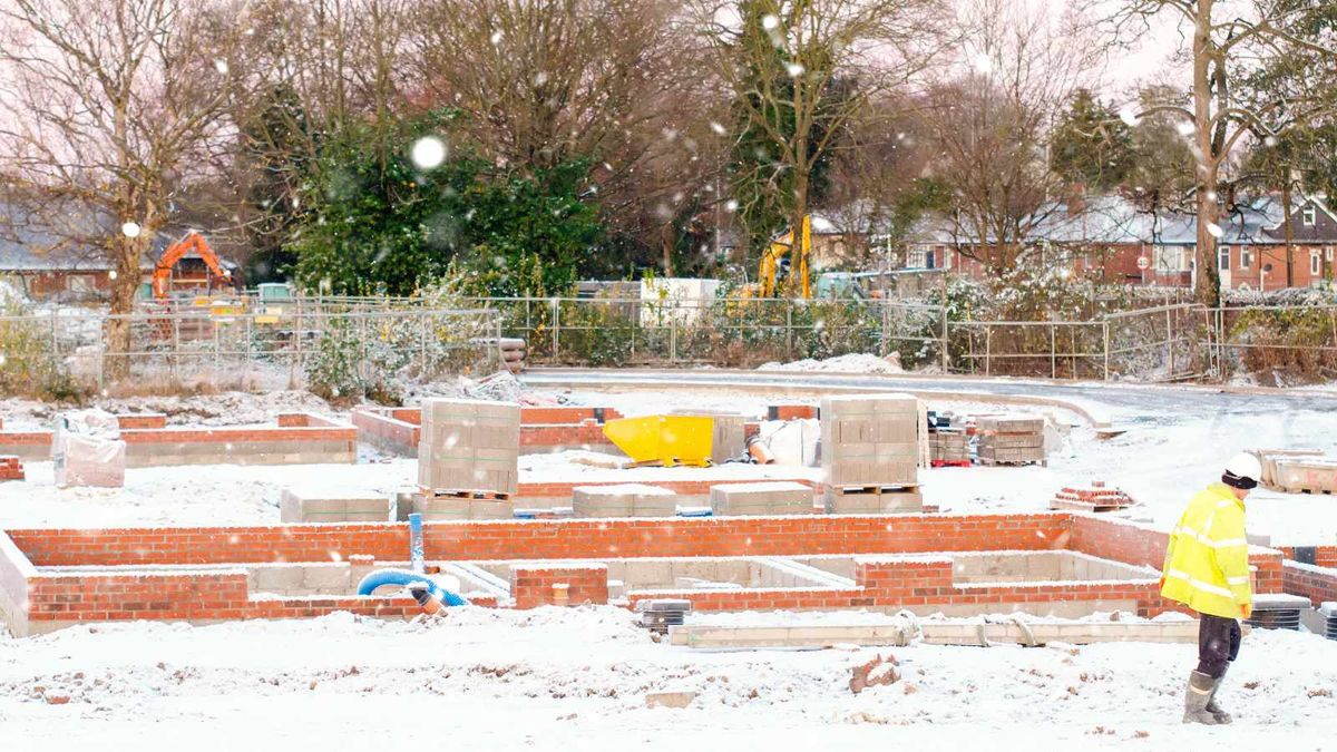 Building site, with foundations and lower walls built, pictured in the snow