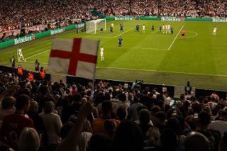 Fans wave a St George's flag as England prepare to take a corner in the Euro 2020 final