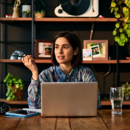 A woman takes a video call from her home office