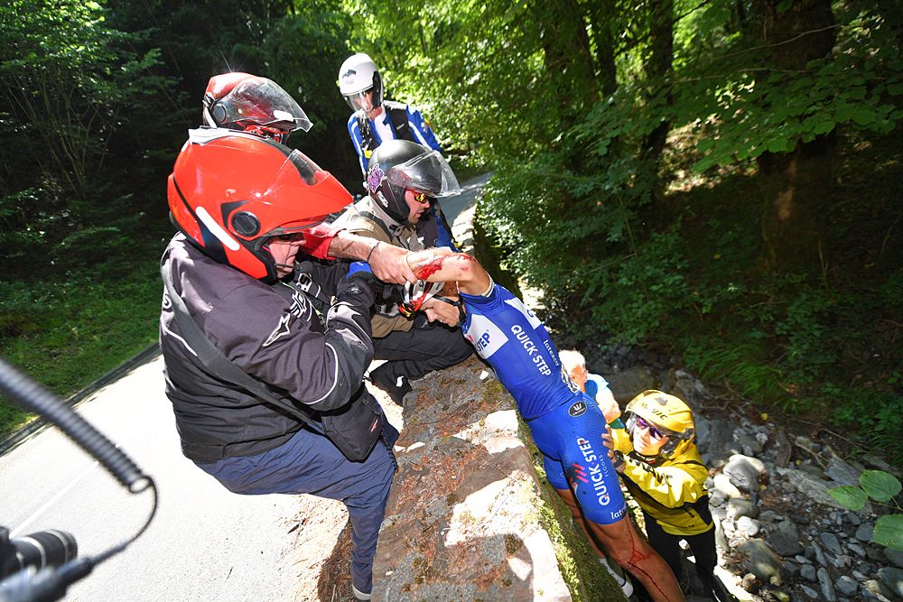 Philippe Gilbert being pulled out of the small ravine at the side of the road where he crashed