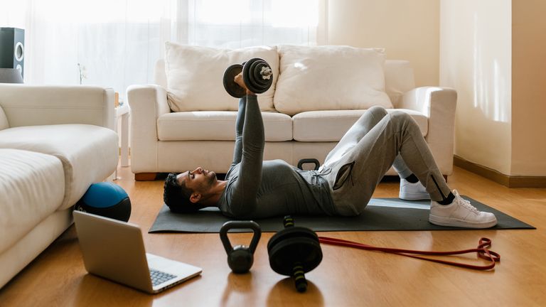 Man doing a dumbbell press at home
