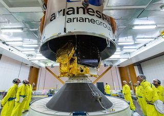 The upper composite of the Ariane 5 rocket — composed of Eutelsat Konnect, the SYLDA payload dispenser system and a protective payload fairing — is lowered over GSAT-30 in preparation for launch.
