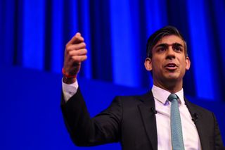 Rishi Sunak speaking at a Business Connect event in North London with a purple background