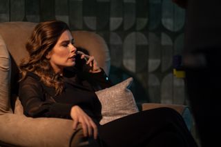 Emily (Rachel Shenton) sits in an armchair in her dimly-lit living room, making a phone call in For Her Sins 
