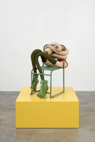 sculpture with green shoes on chair