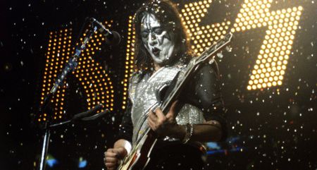 Ace Frehley of Kiss performs in 1996 with confetti filling the air and the band's logo in lights