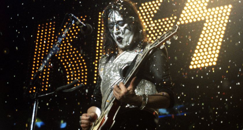 Ace Frehley of Kiss performs in 1996 with confetti filling the air and the band's logo in lights