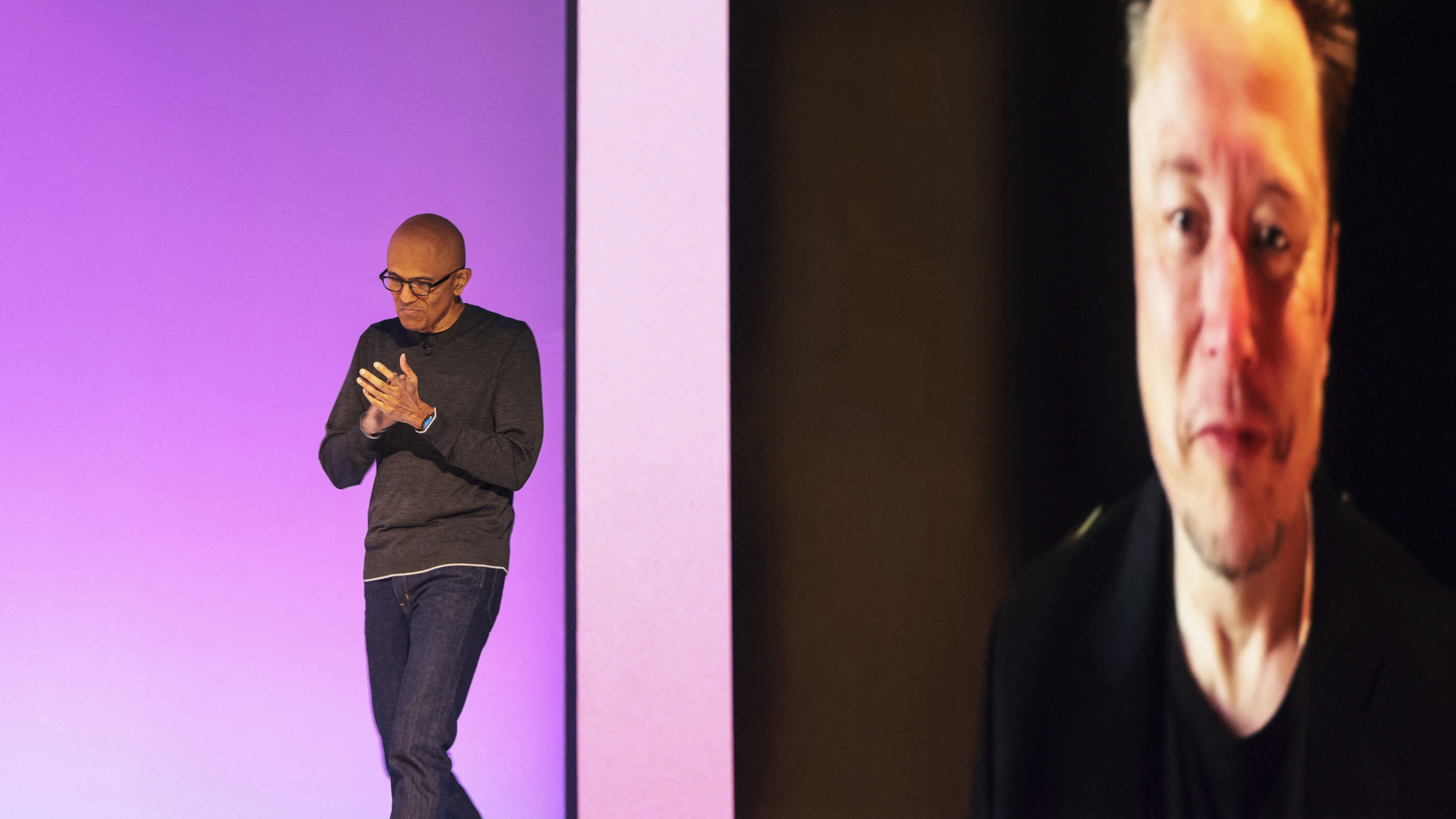 Microsoft Chairman and Chief Executive Officer Satya Nadella (L) returns to the stage after a pre-recorded interview with Elon Musk was played following the announcement that Grok AI, by Musk's artificial intelligence start up xAI, will be available on Microsoft's Foundry Models, during the Microsoft Build conference opening keynote in Seattle, Washington on May 19, 2025. (Photo by Jason Redmond / AFP) (Photo by JASON REDMOND/AFP via Getty Images)