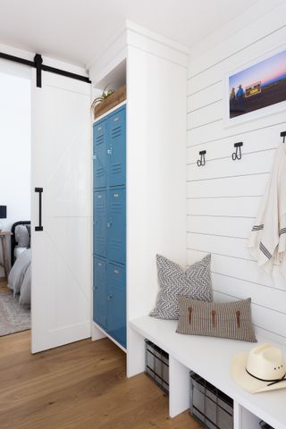 white farmhouse hallway with blue lockers and bench seating