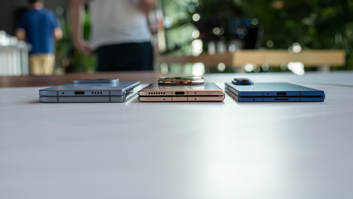 Comparing the size and thickness of the Google Pixel 10 Pro Fold (light blue), Honor Magic V5 (gold/copper), and Samsung Galaxy Z Fold 7 (dark blue)