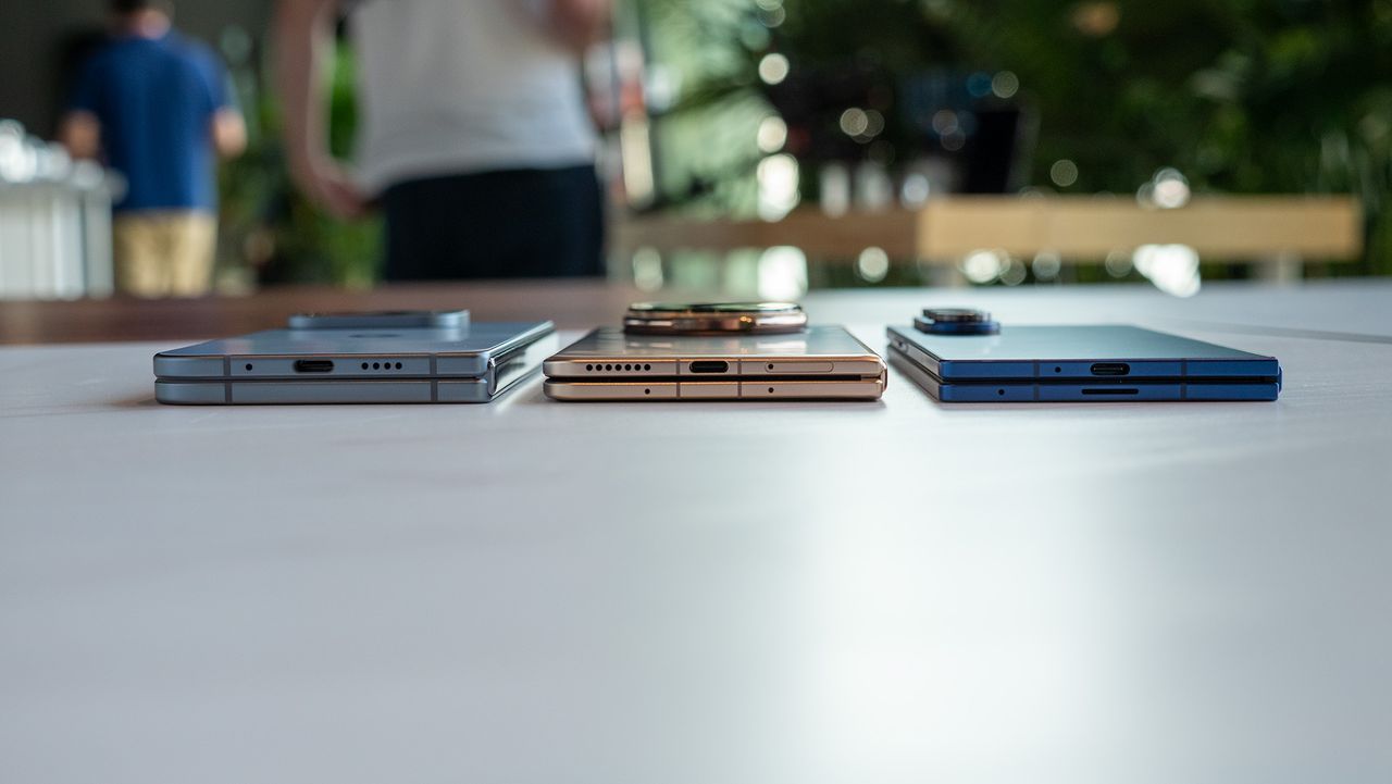 Comparing the size and thickness of the Google Pixel 10 Pro Fold (light blue), Honor Magic V5 (gold/copper), and Samsung Galaxy Z Fold 7 (dark blue)