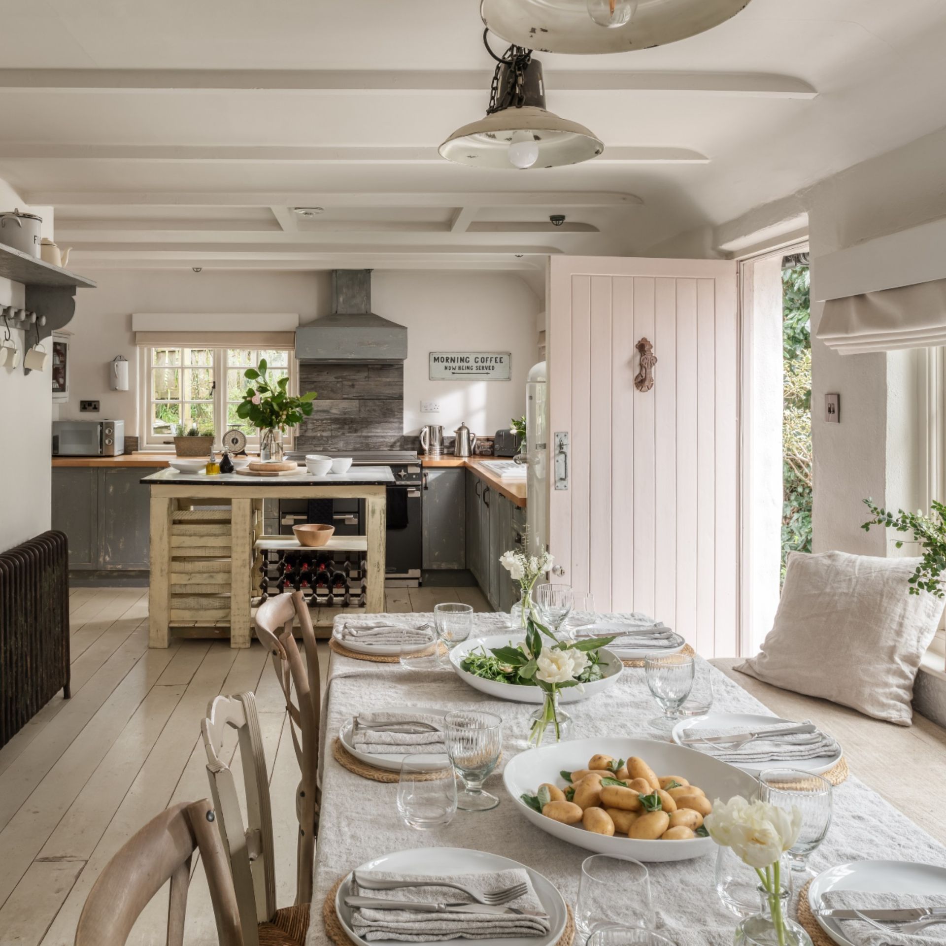 Kitchen at the Unique Homestays x The White Company Fable house, with an island and dining table, and door leading out to the garden