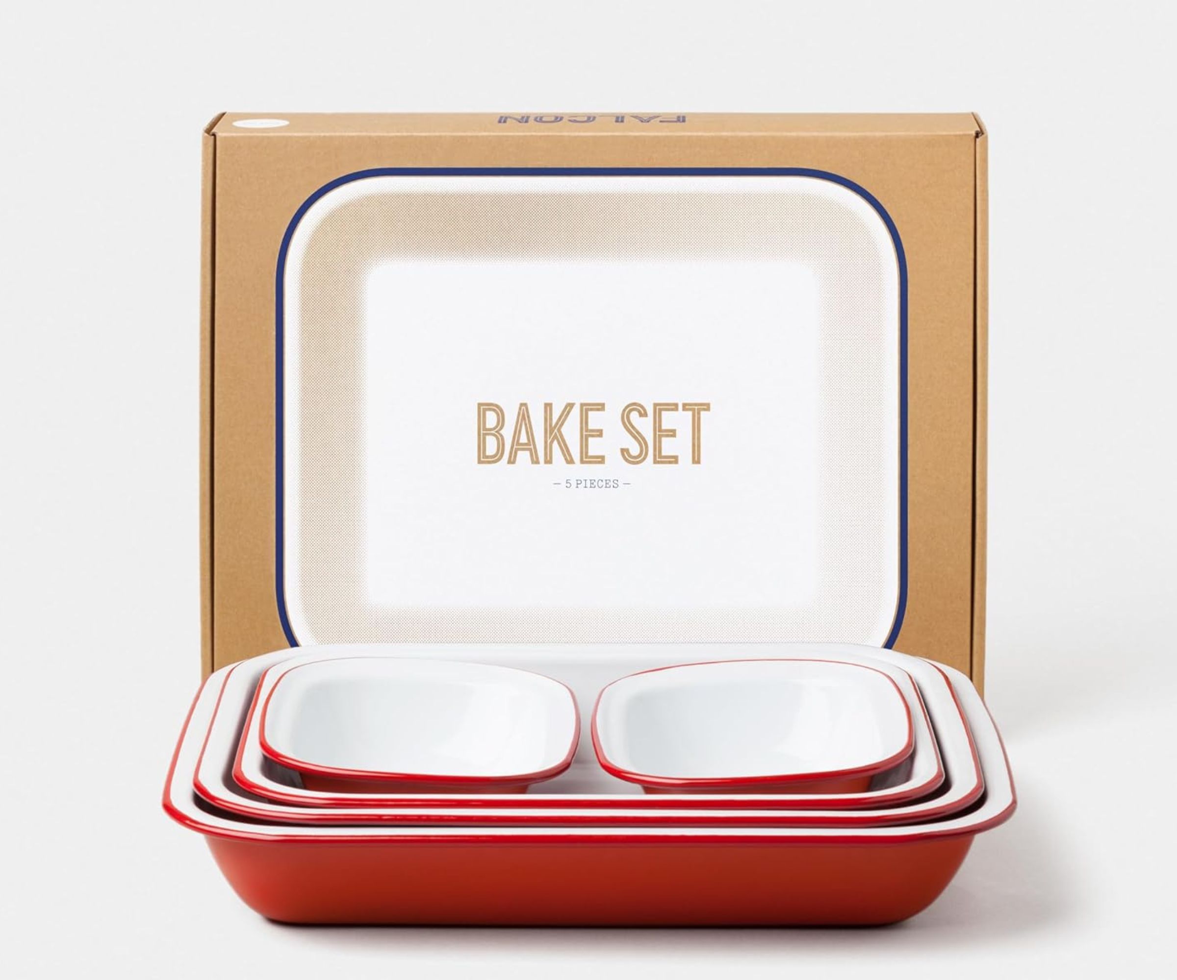 A set of white enamel dishes with red rims, in front of a cardboard box.