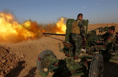 Kurdish peshmerga fighters fire an anti-tank cannon near Mosul.