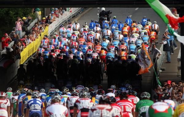 The shadow of a bridge cuts through the peloton early in the race.