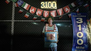 Andrea Marcato of Italy poses for a photo while holding a portrait of Indian spiritual personality Sri Chinmoy after winning the 'Self-Transcendence 