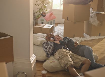 A happy excited couple in their new home surrounded by boxes