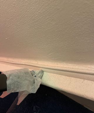 Vacuuming baseboard with a dryer sheet fastened at the end of the nozzle