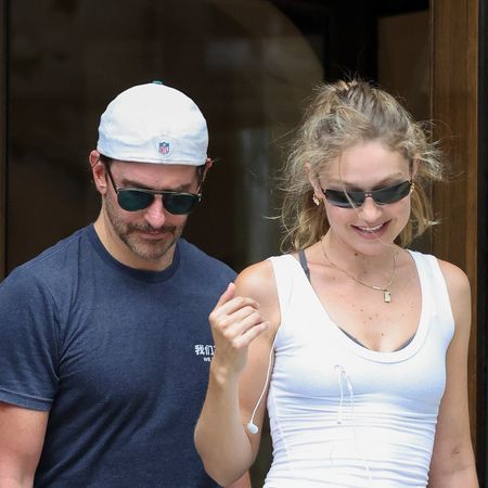 Gigi Hadid with Bradley Cooper in Paris, wearing a white tank top, gray leggings, and brown suede New Balance sneakers