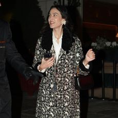 Alexa Chung wears an ornate jacket with straight-leg jeans, lilac heels and oversized earrings.