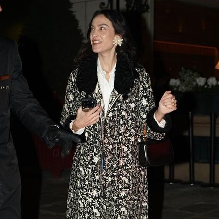 Alexa Chung wears an ornate jacket with straight-leg jeans, lilac heels and oversized earrings.