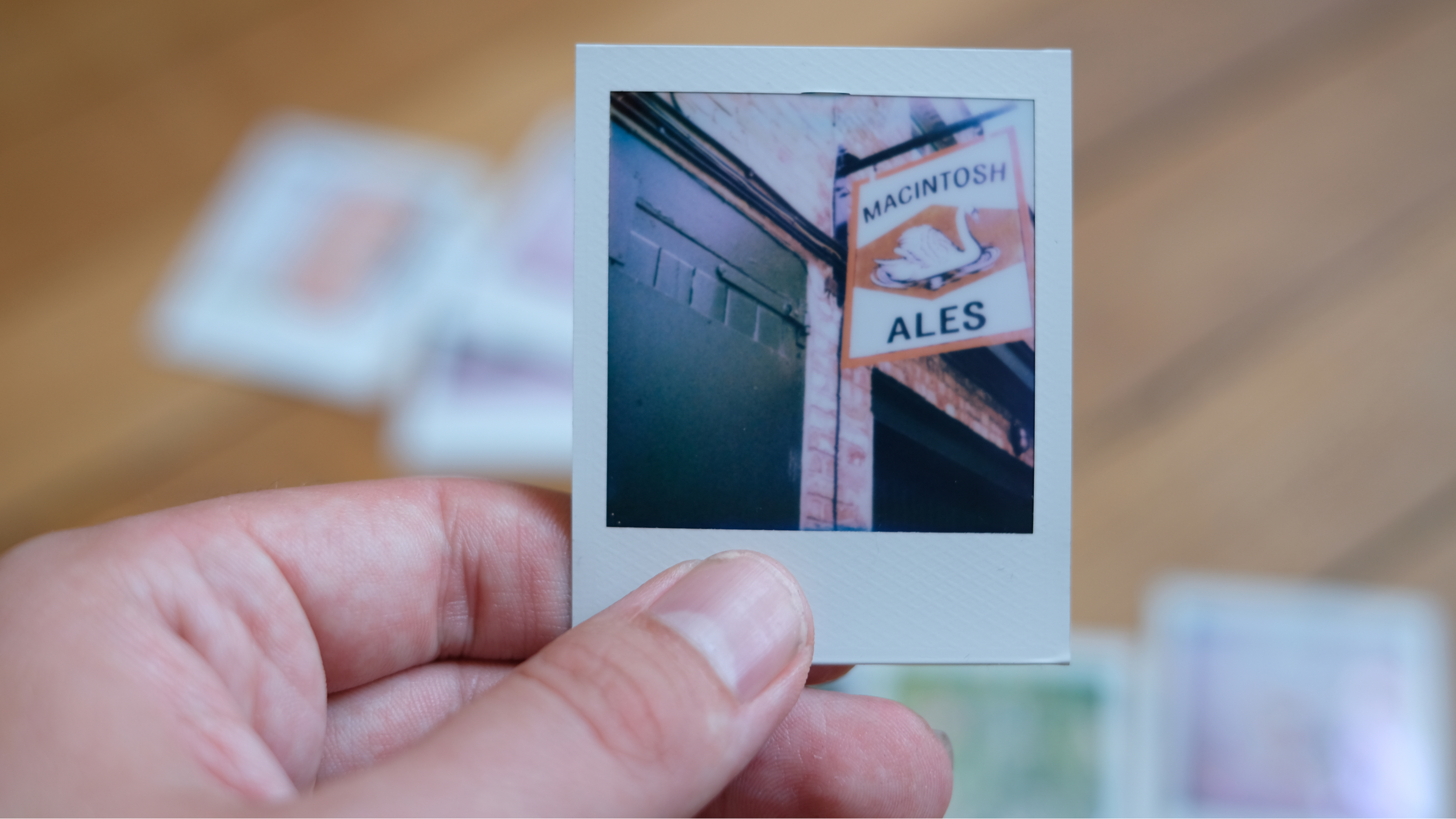 Photograph of prints made with Polaroid Go Gen 3, showing a hanging pub sign beside a green door
