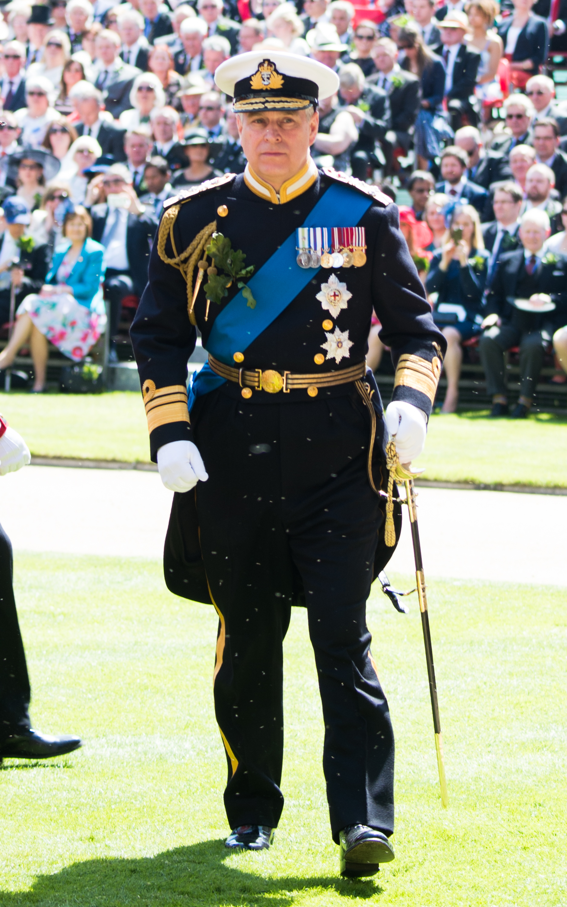 The former Prince Andrew wears his military uniform and walks away from a crowd of people