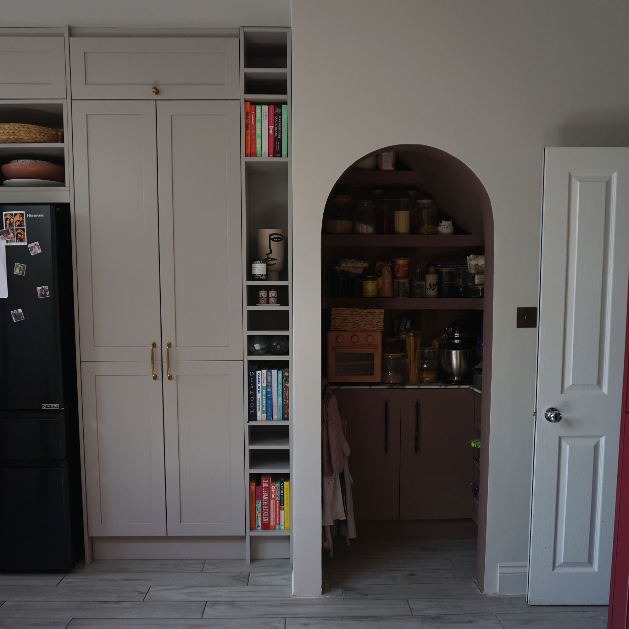 Arch doorway in kitchen leading to walk-in pantry