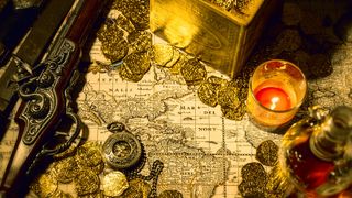 Gold coins, pirate map, flintlock, candle, bottle of liquor