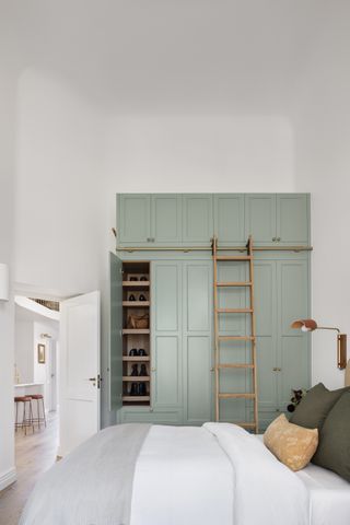 A bedroom with ceiling high storage