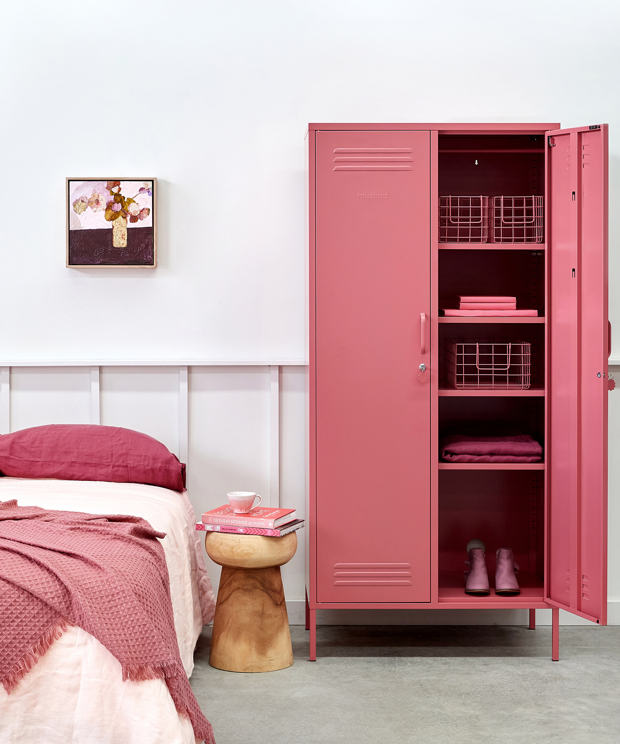 A feminine bedroom with white wall paneling and berry pink Mustard Made locker unit