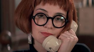 Annie Potts answers the phone wearing black circular glasses in Ghostbusters II.