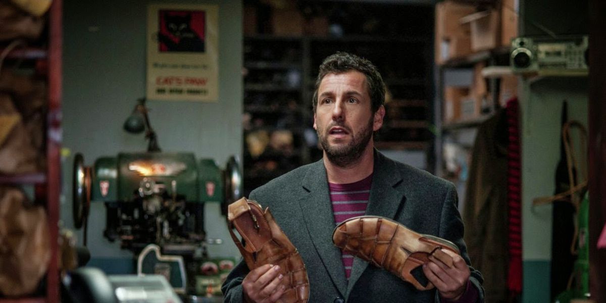 Max Simkin (Adam Sandler) holds a pair of shoes and looks confused in a scene from &#039;The Cobbler&#039;