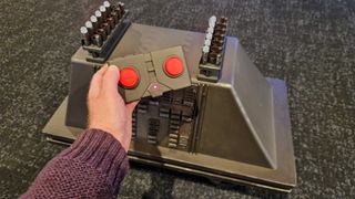 RC Mouse Droid with a hand holding the remote control