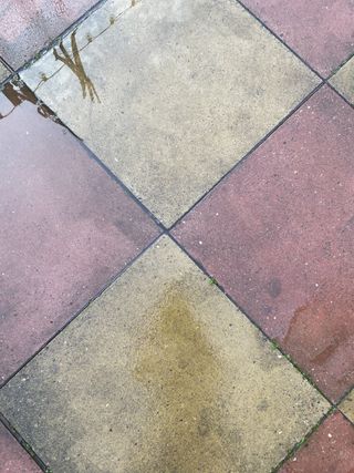 a patio being cleaned with a pressure washer