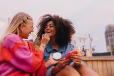 Two female friends are laughing and smiling together. 