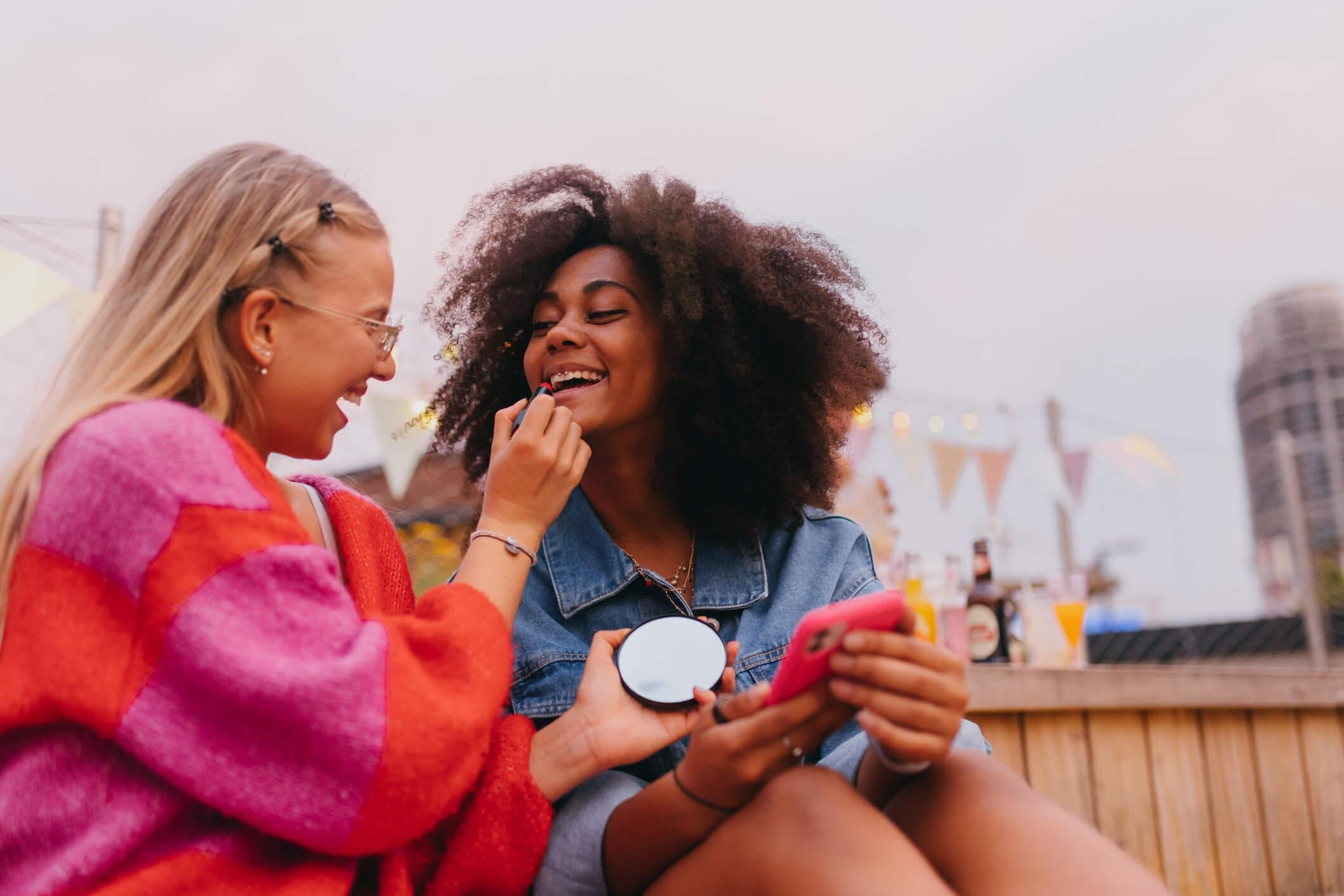  Two female friends are laughing and smiling together.  