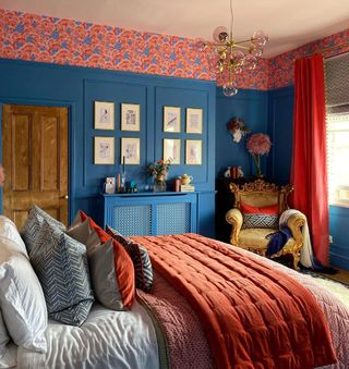 A colorful bedroom with a picture rail decorated with pink floral patterned wallpaper