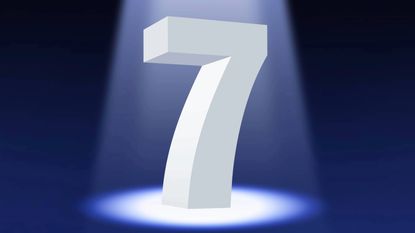 A white number seven in 3D standing on a dark background illuminated by a spotlight