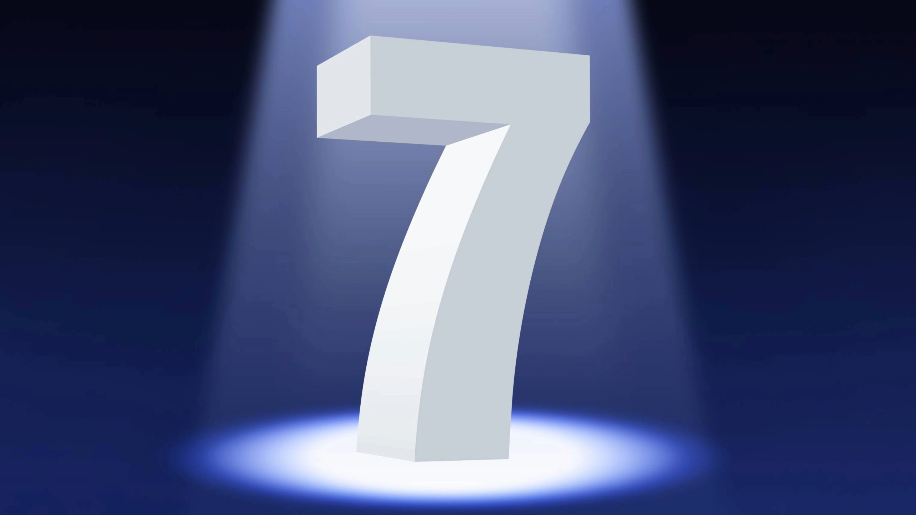 A white number seven in 3D standing on a dark background illuminated by a spotlight