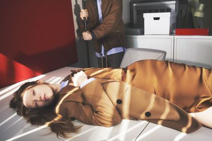 Woman lying on white table wearing Lucas Ossendrijver collection