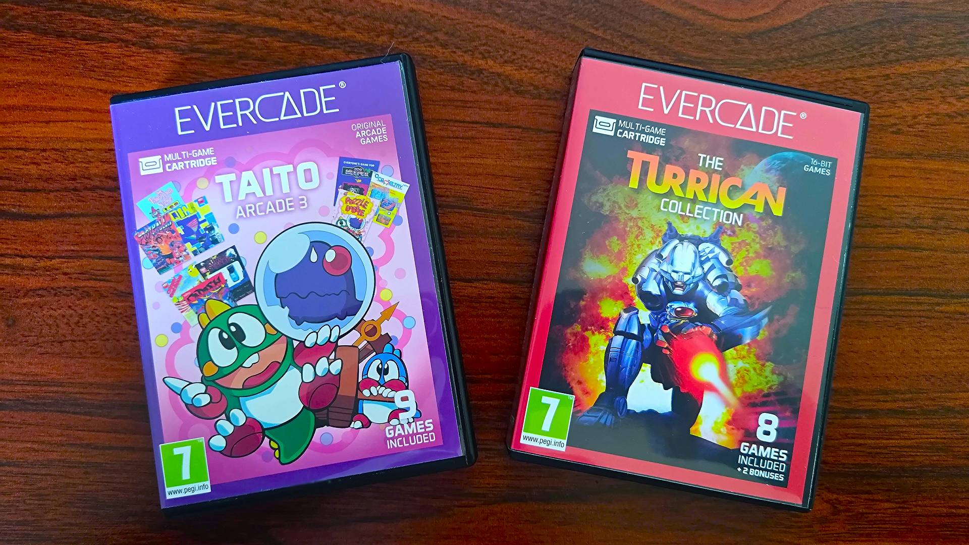 Taito Arcade 3 Evercade box on left and The Turrican Collection on right sitting on woodgrain desk.