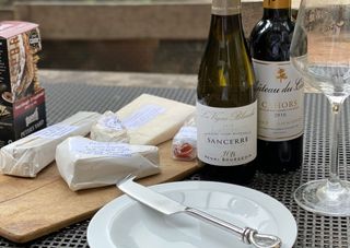 A cheese spread and two bottles of wine