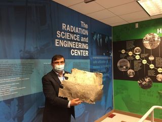 Kenan Ünlü poses with the piece of aluminum thought to come from Earhart's plane.