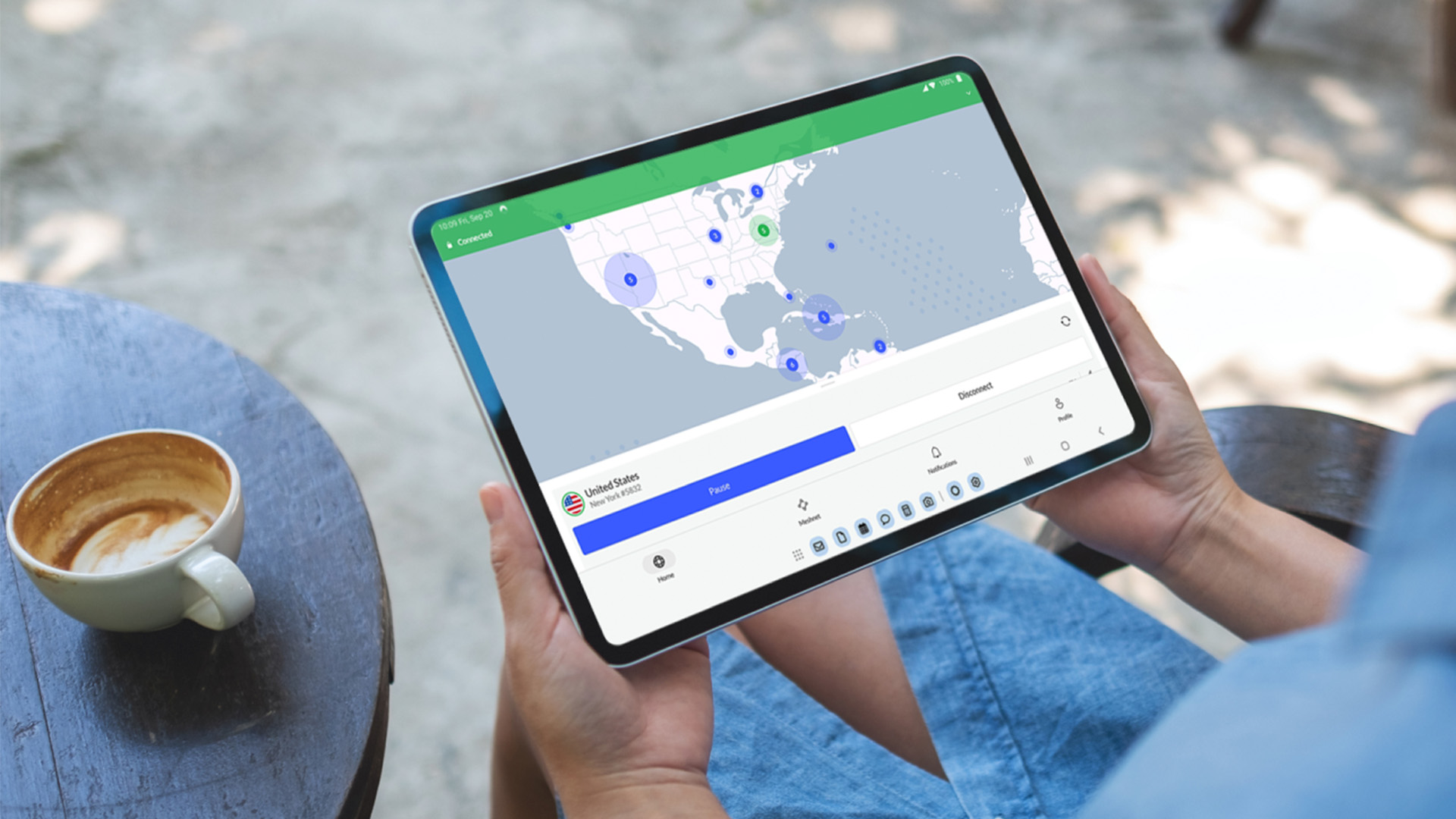 A person holding a tablet in their hands with the screen showing a NordVPN connection map