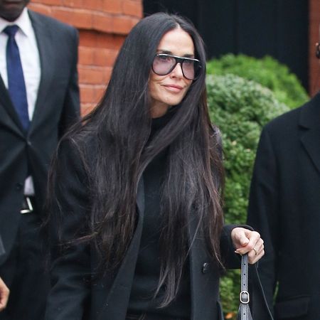 Demi Moore wearing a black coat, sweater, and jeans with Gucci shoes and the Gucci Jackie Slim Shoulder Bag