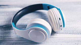 White and blue headphones on a distressed wood surface