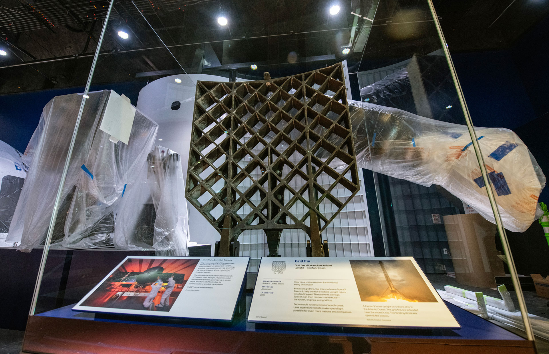 a grid work piece of space hardware is prepared for museum display