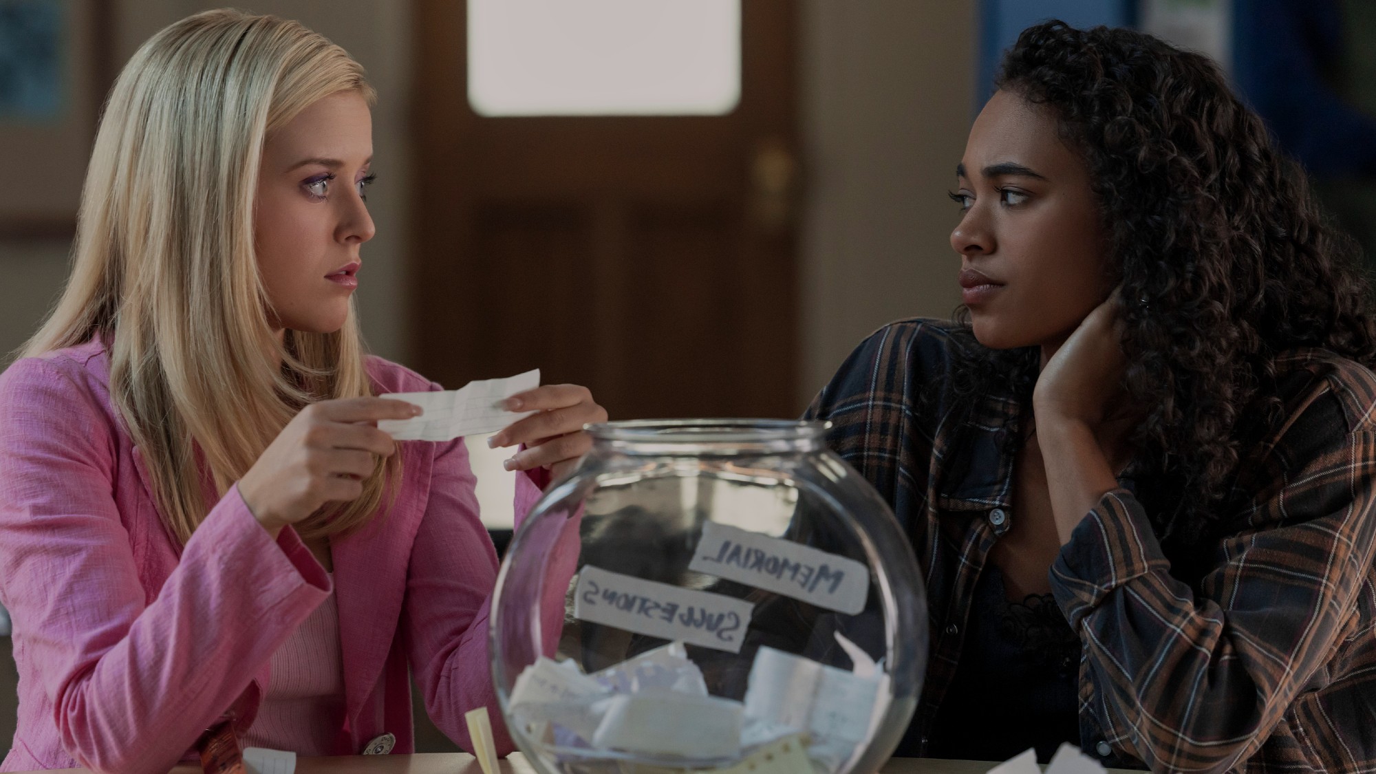 Elle holding a piece of paper and Kimberly looking at her.