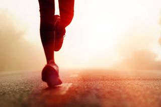 Image of a person's legs wearing running shoes running in the desert